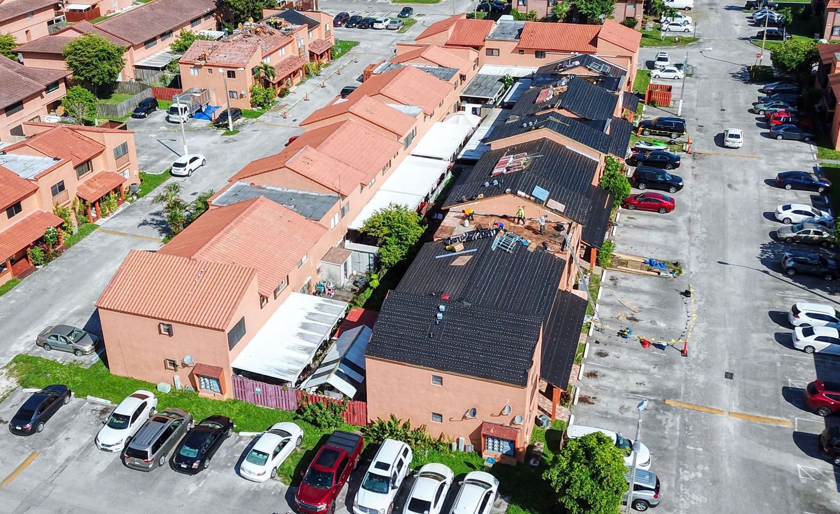 An aerial view of a residential area with a lot of cars parked in front of houses.