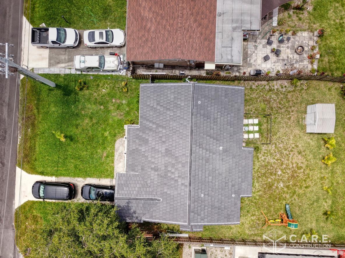 An aerial view of a house with cars parked in front of it.