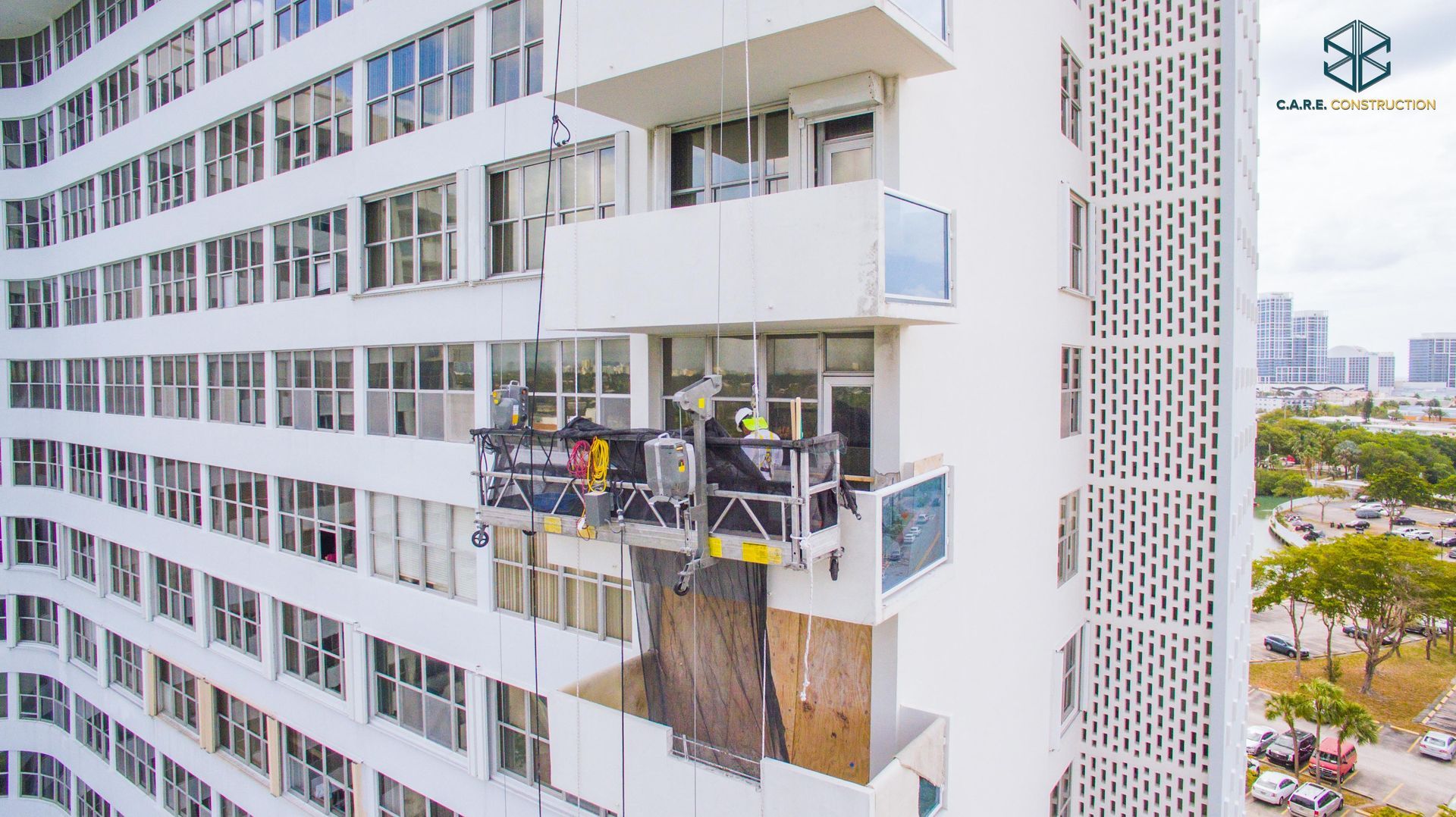 A group of people are working on the side of a tall building.