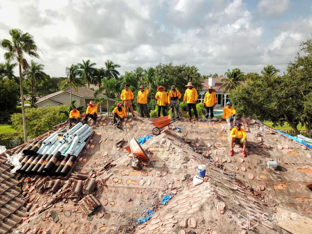 A group of construction workers are standing on top of a roof.