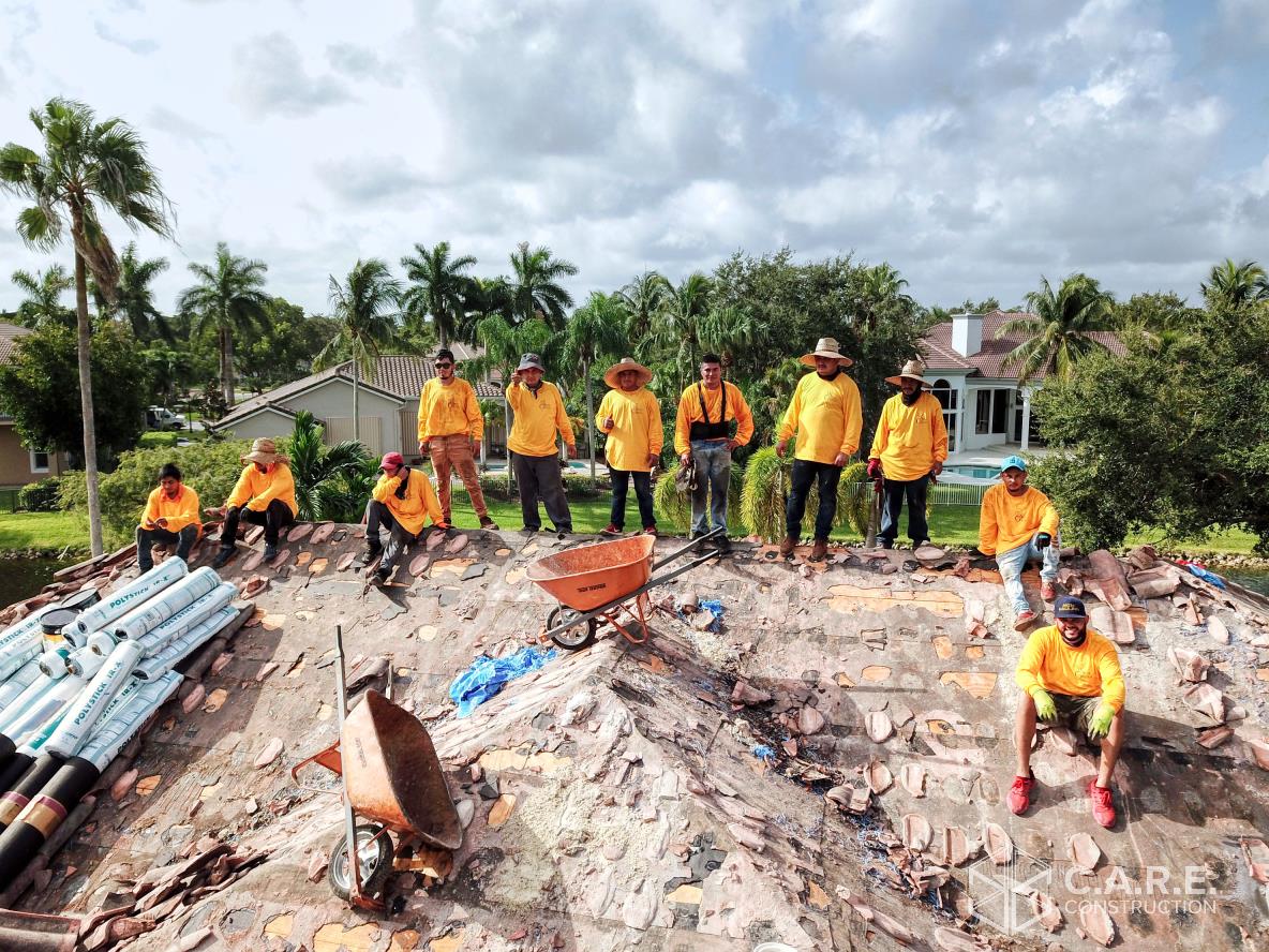 A group of construction workers are posing for a picture on top of a pile of rubble.