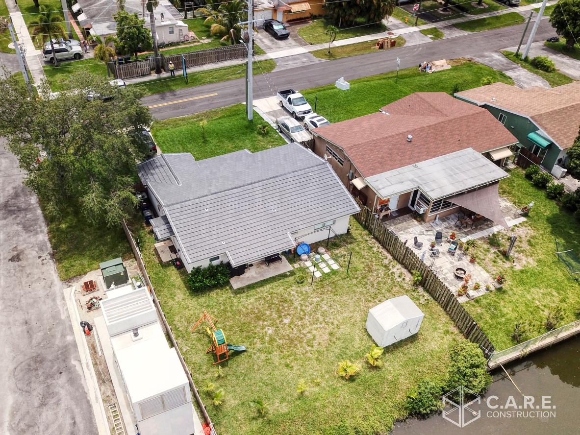 An aerial view of a residential area with houses and a canal.