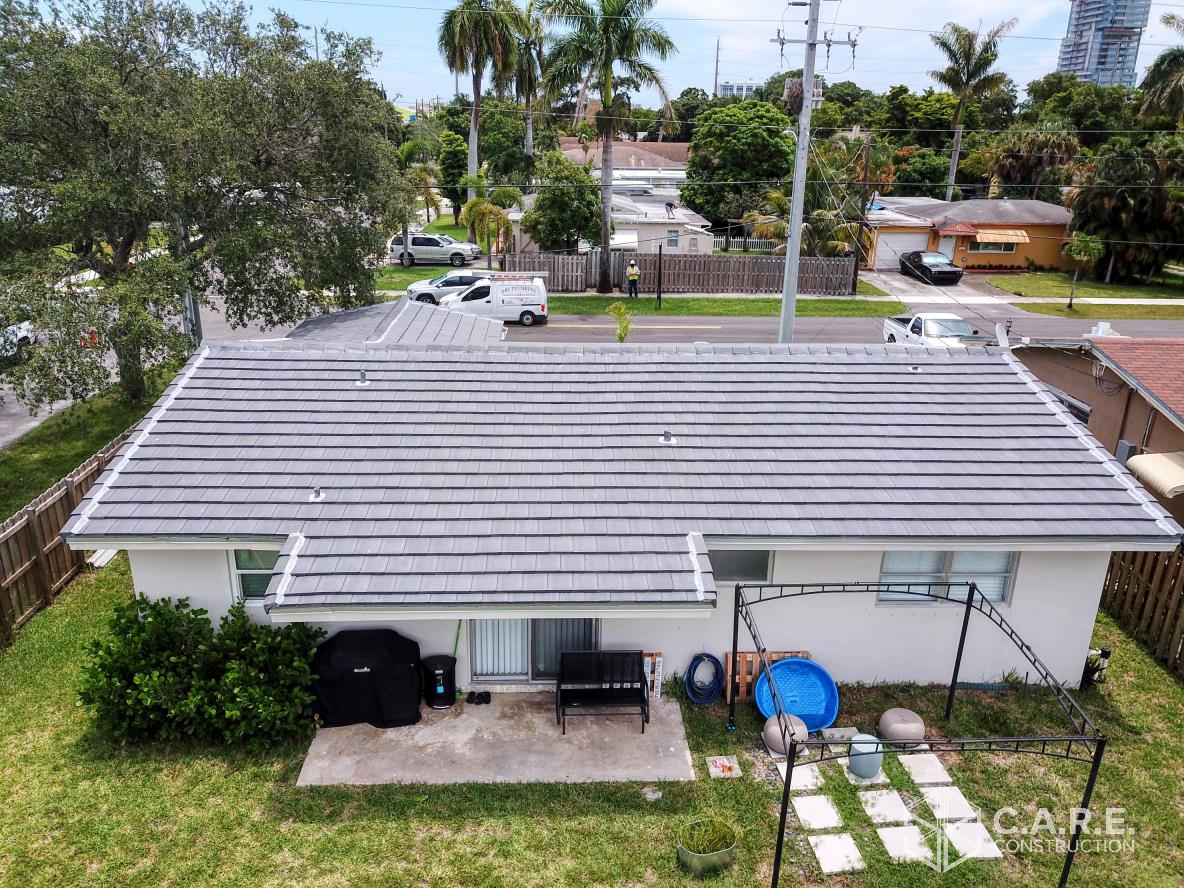 An aerial view of a house with a solar panel on the roof.