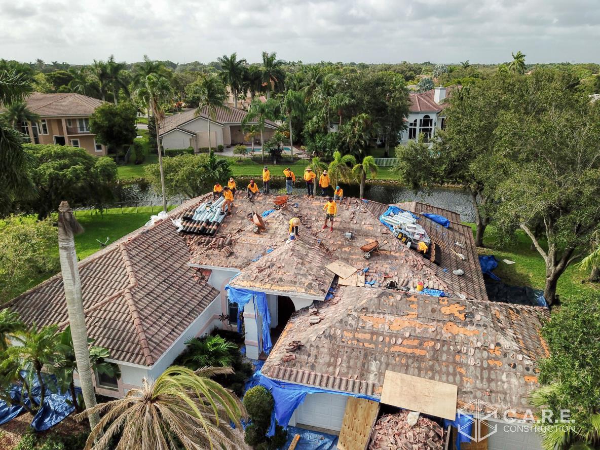 An aerial view of a house under construction with workers on the roof.