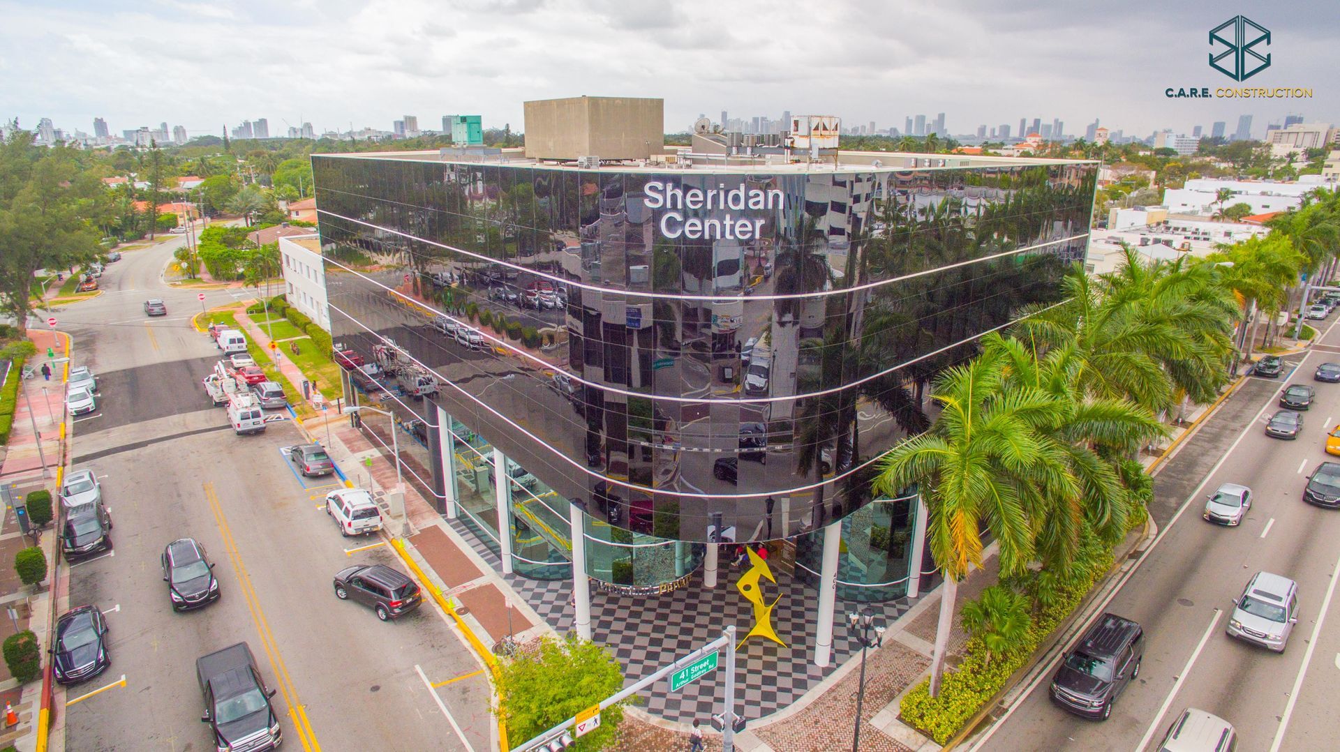 An aerial view of a busy intersection with a large building in the background.