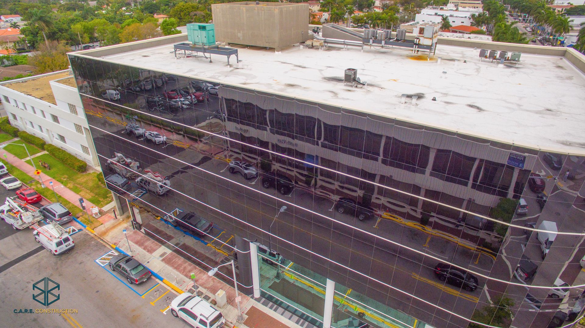 An aerial view of a large building with cars parked in front of it.