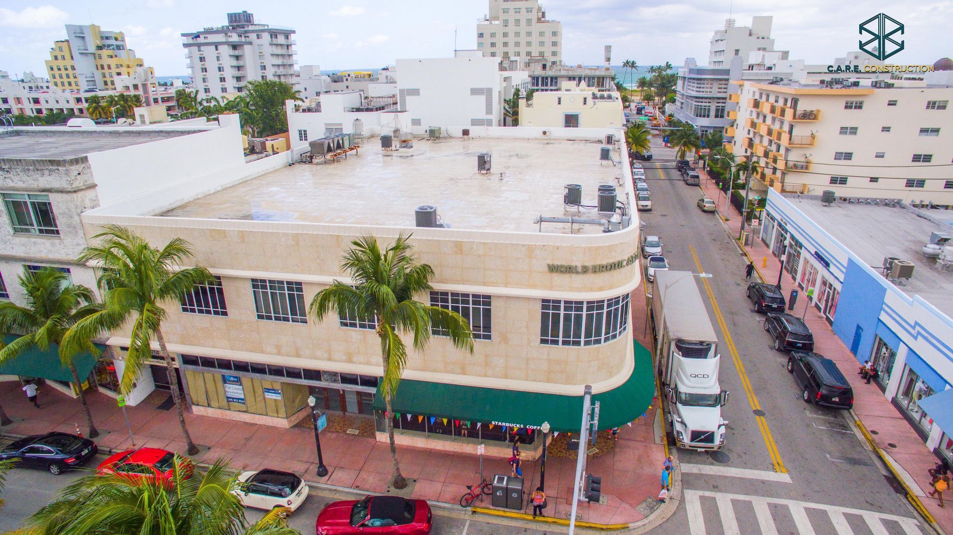 An aerial view of a city street with a large building in the background