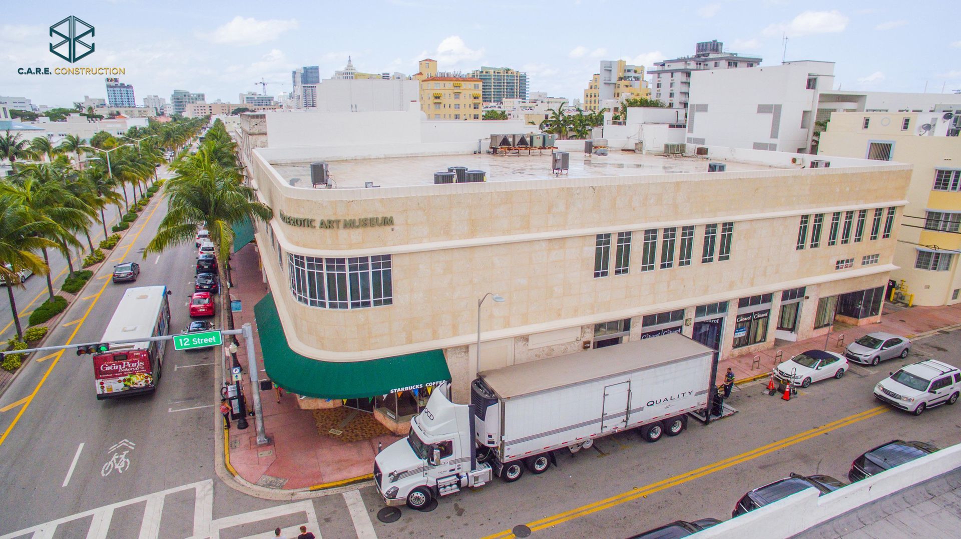 A white truck is parked in front of a large building