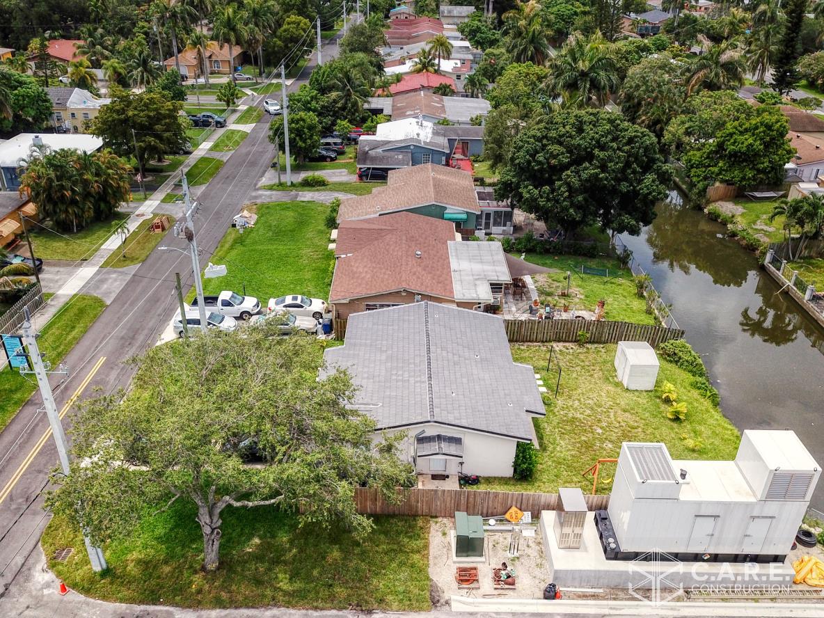 An aerial view of a residential area with a river in the background.