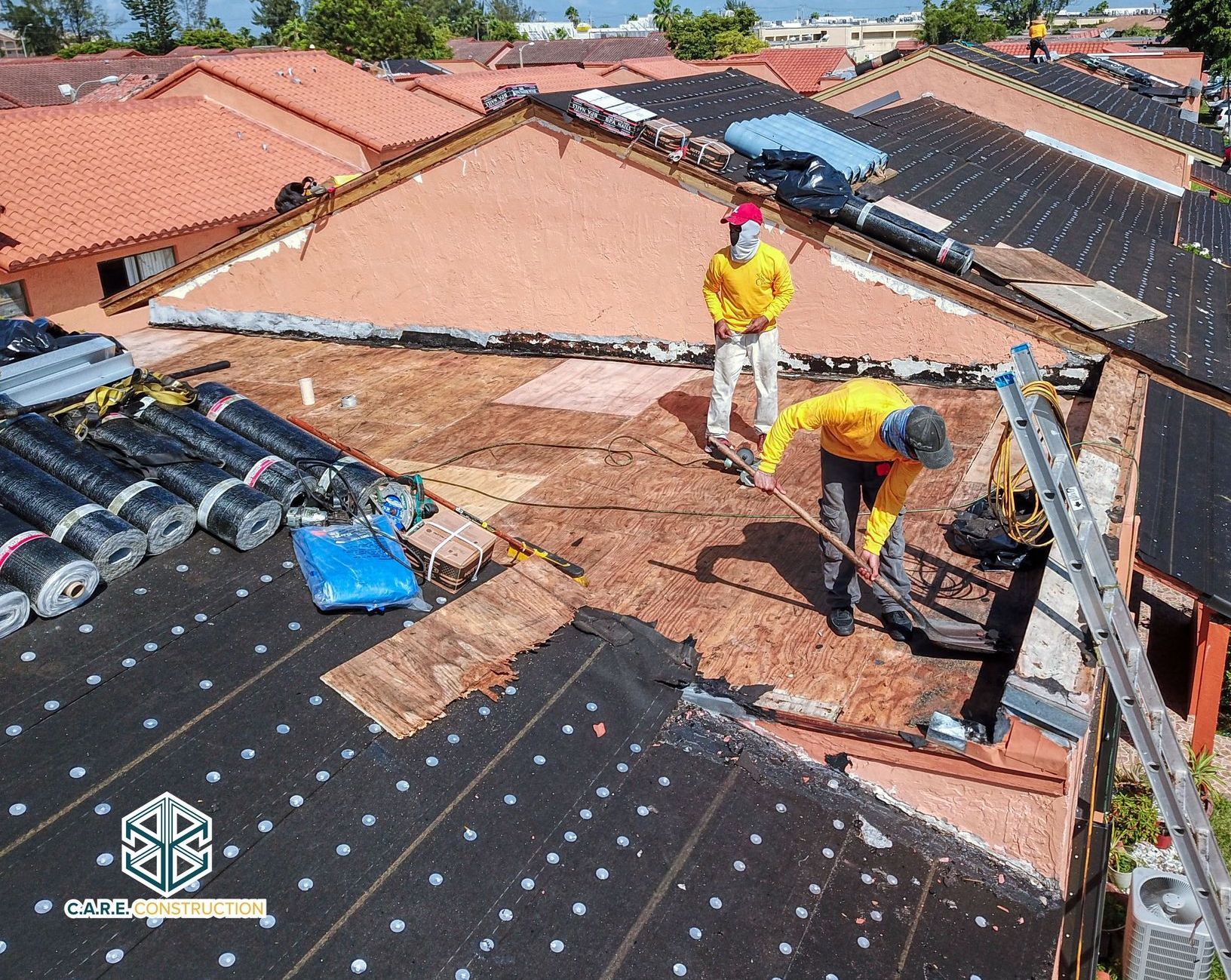 A group of men are working on the roof of a house.