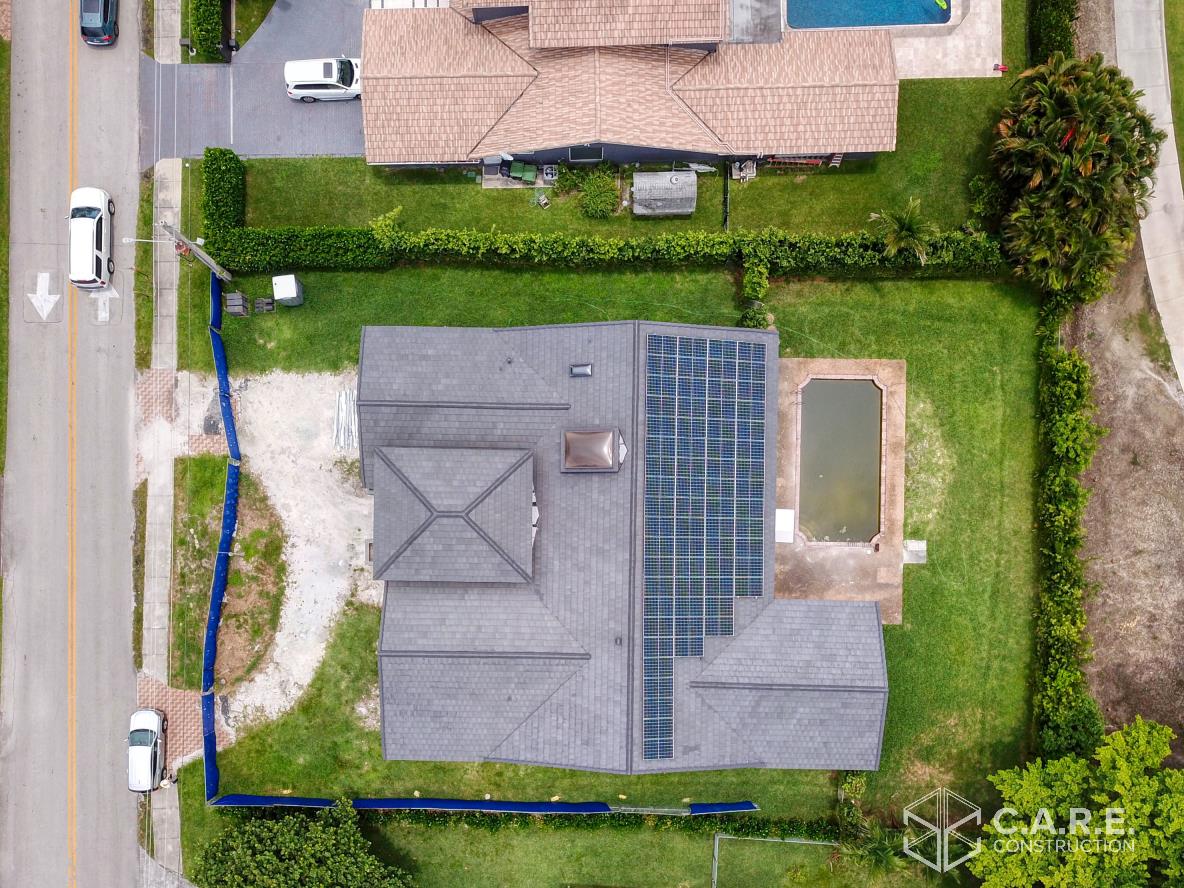 An aerial view of a house with solar panels on the roof