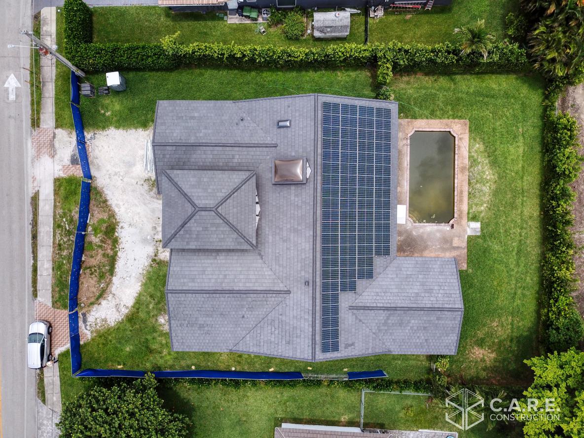 An aerial view of a house with solar panels on the roof