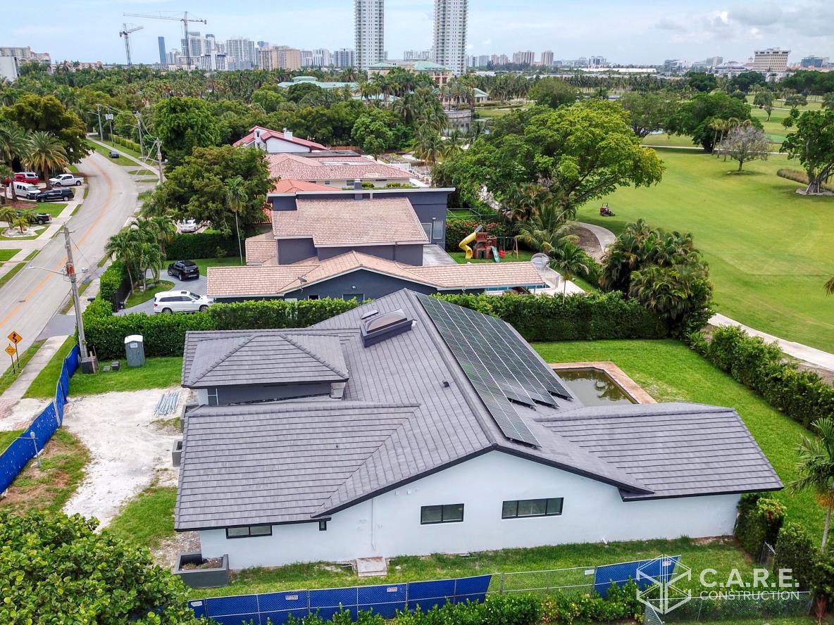 An aerial view of a house with solar panels on the roof