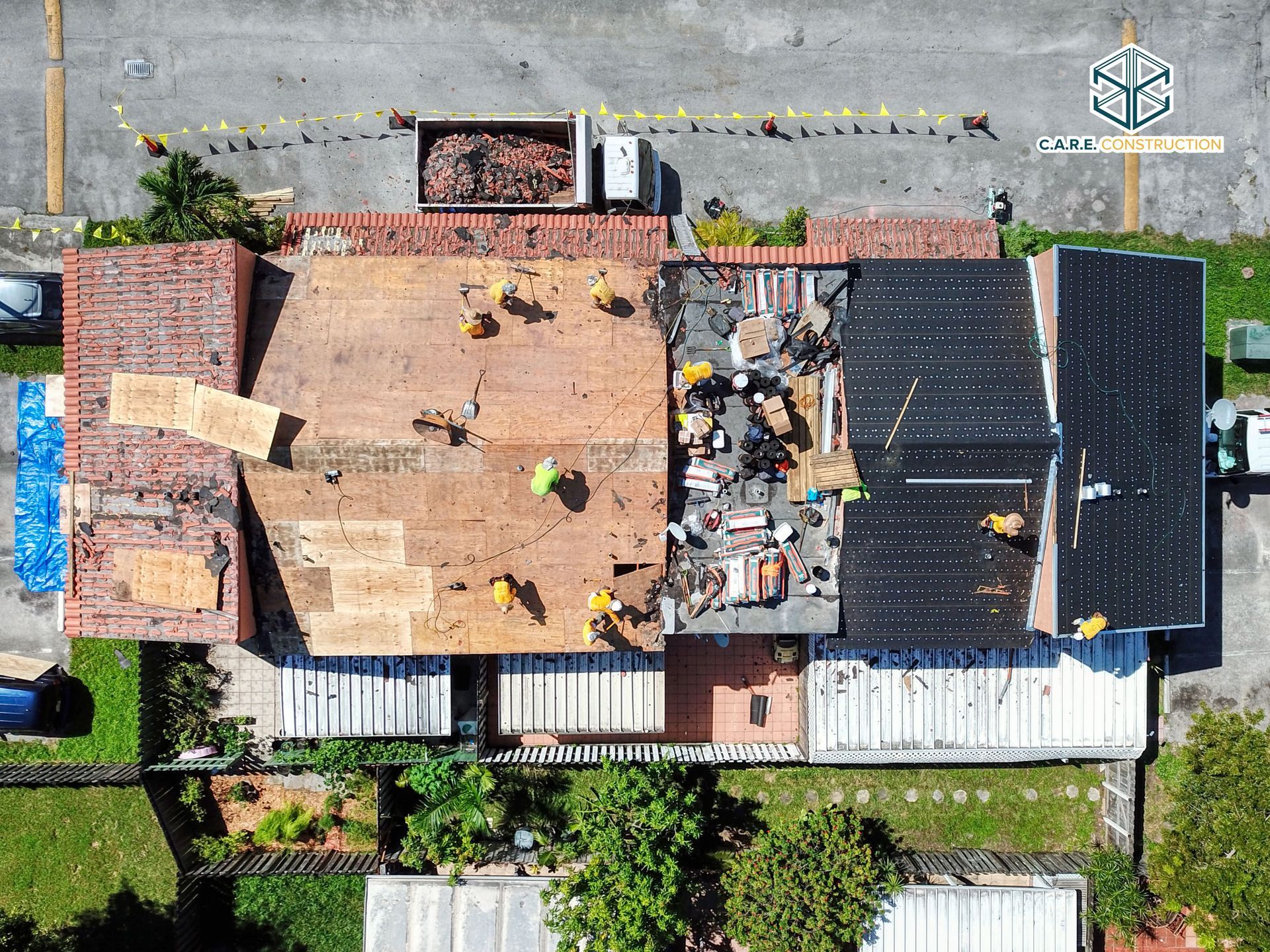 An aerial view of a house under construction with workers on the roof.