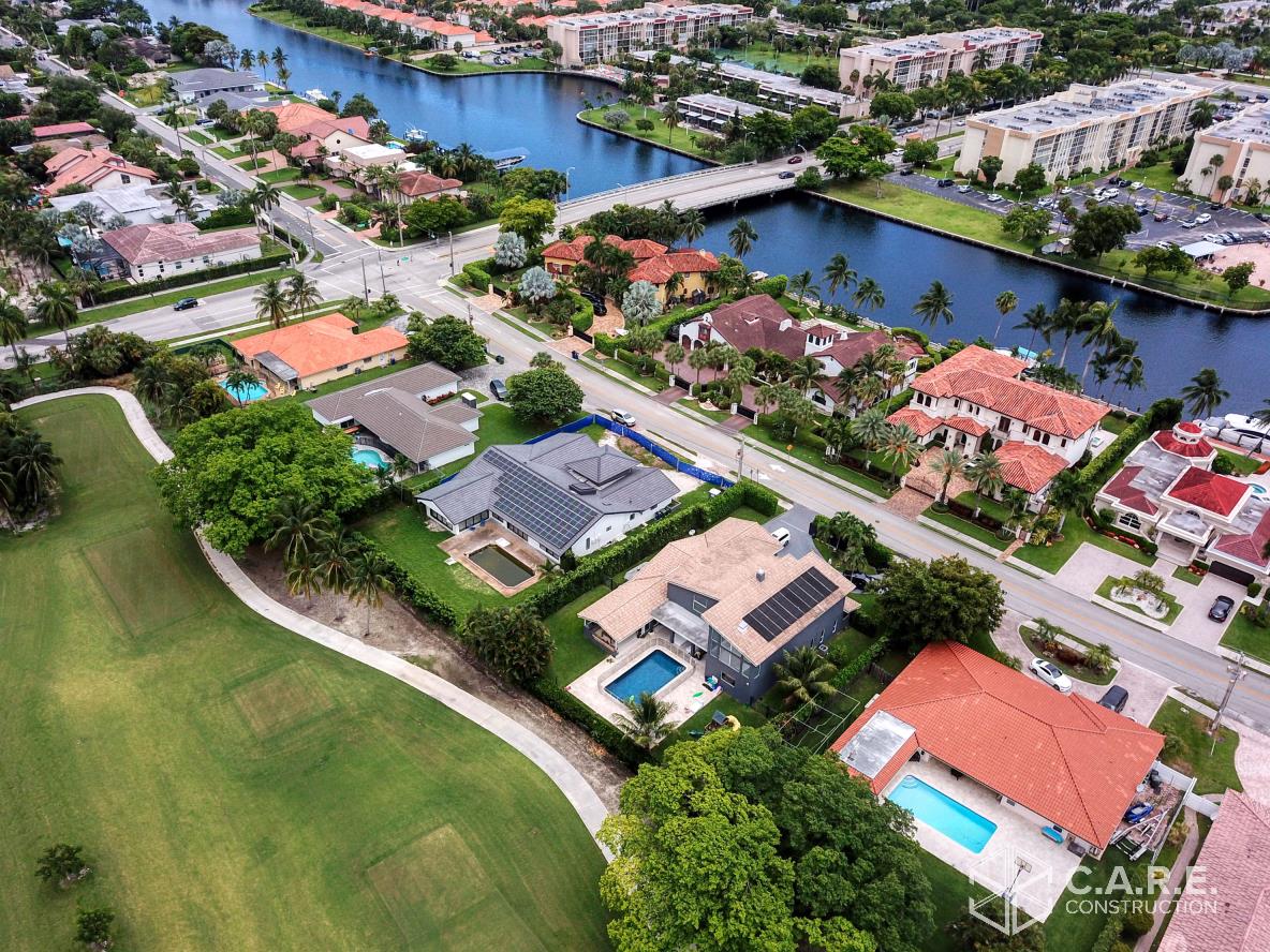 An aerial view of a residential area with houses and a river.