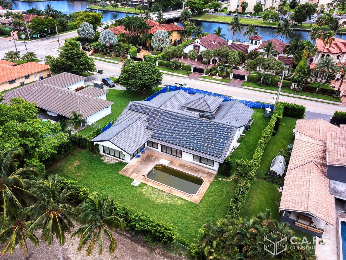 An aerial view of a house with a pool in a residential area.