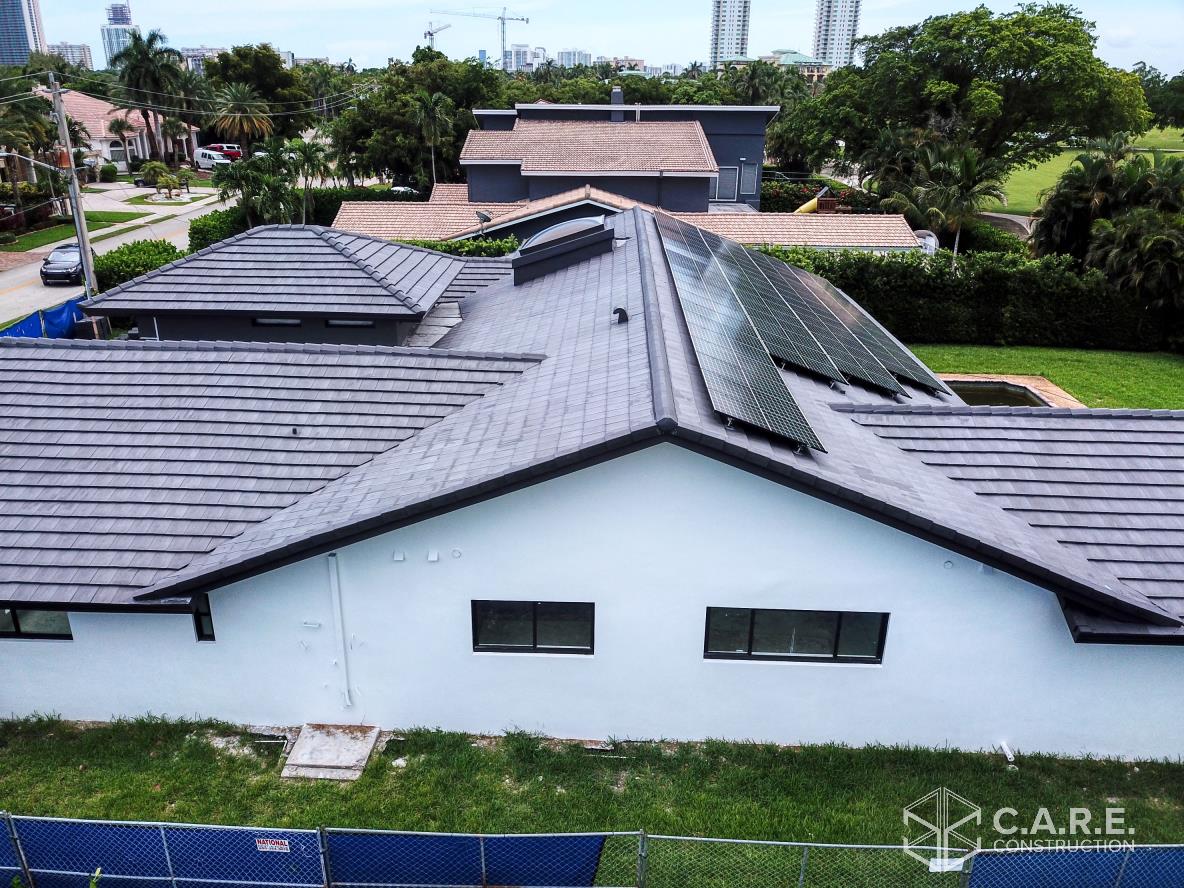 An aerial view of a house with solar panels on the roof