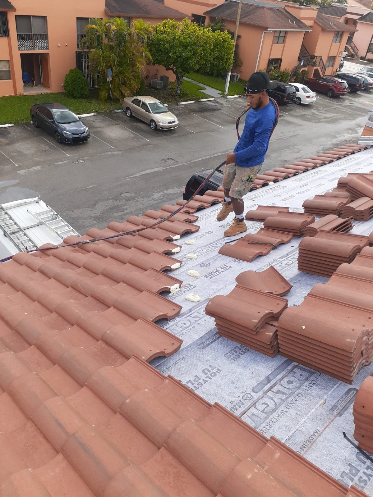 A man is standing on top of a tiled roof.