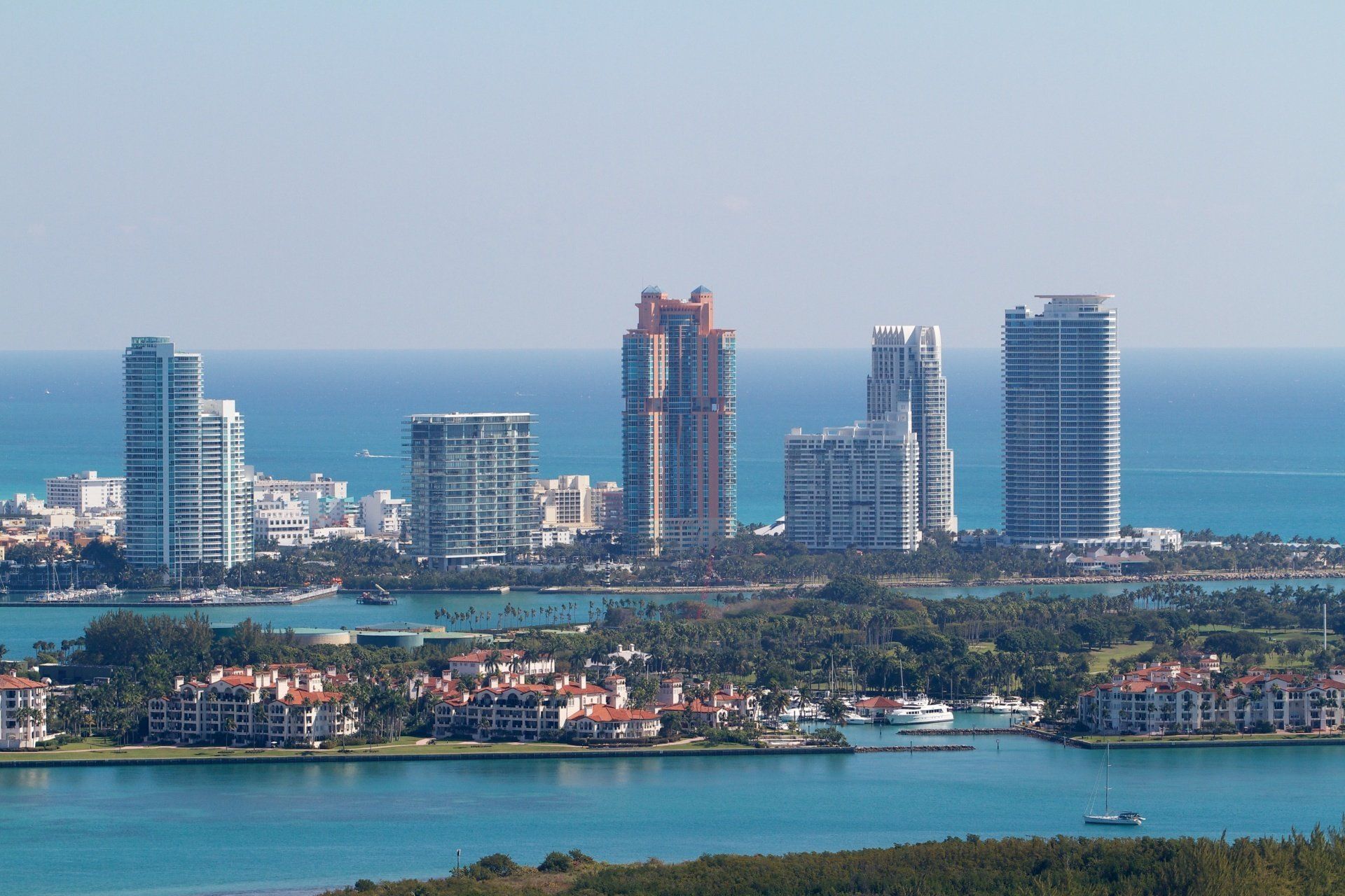 A city skyline with lots of tall buildings and a body of water in the foreground