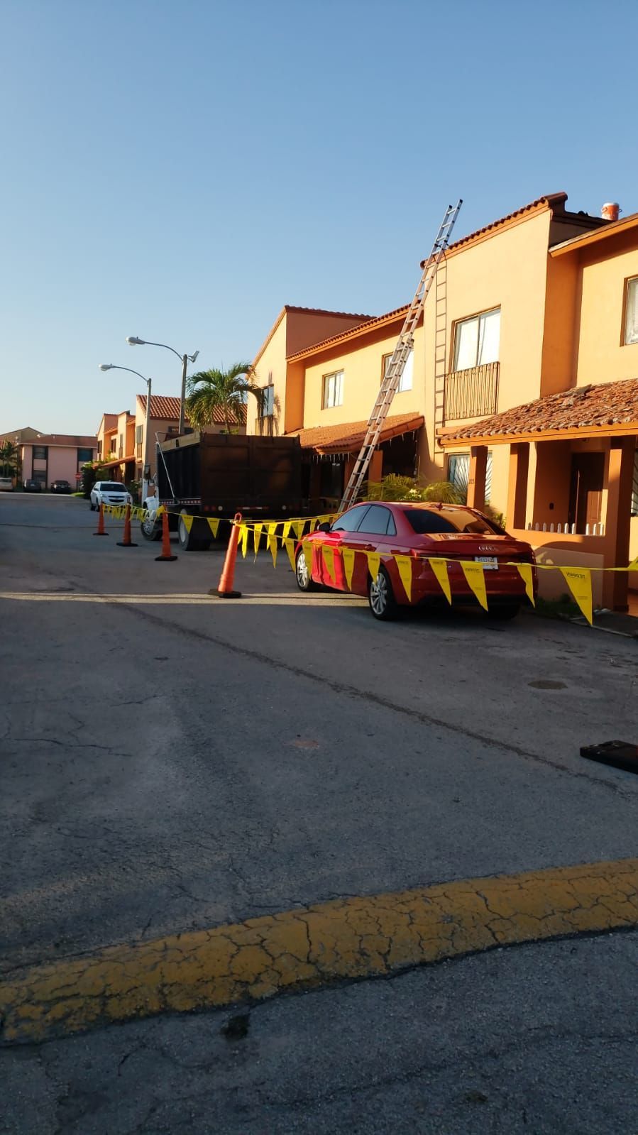 A red car is parked in front of a row of houses