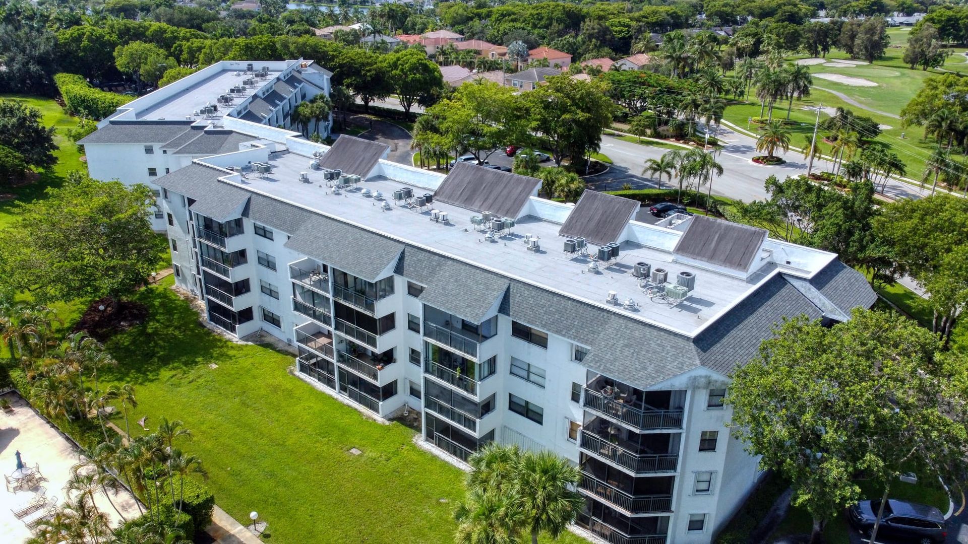 An aerial view of a large apartment building with solar panels on the roof