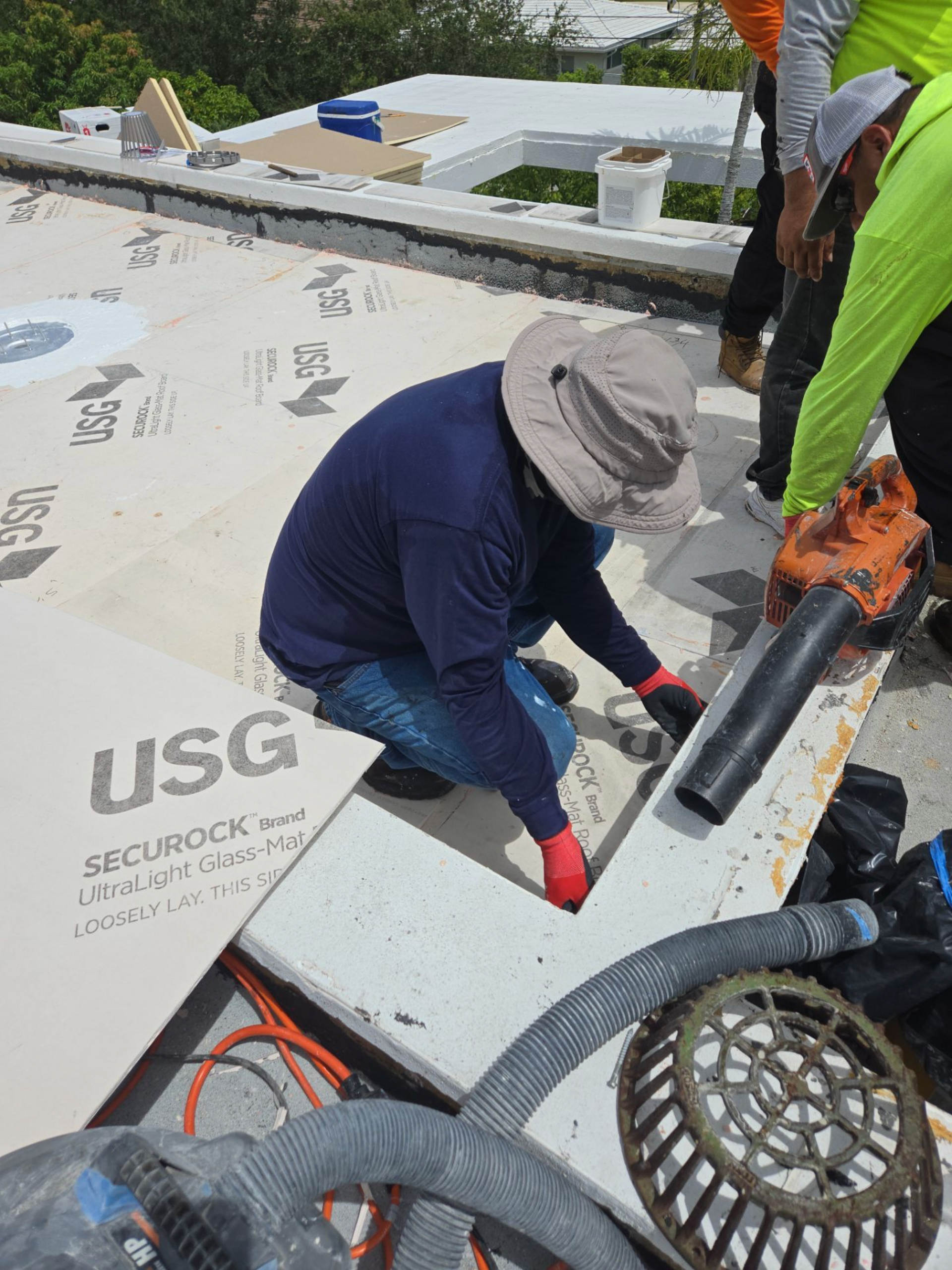 A man is working on a roof with a vacuum cleaner.