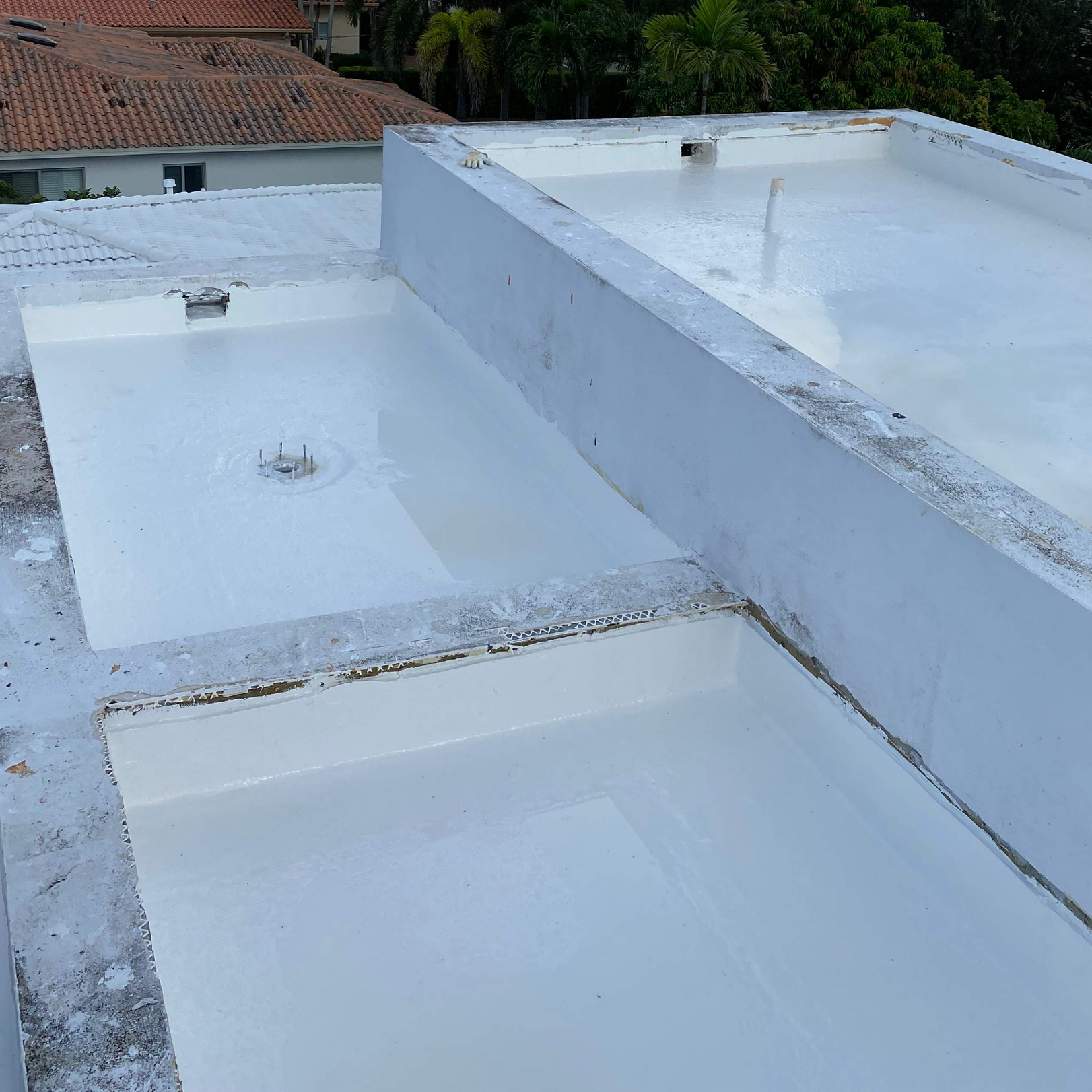 A white roof with a drain on the side of it