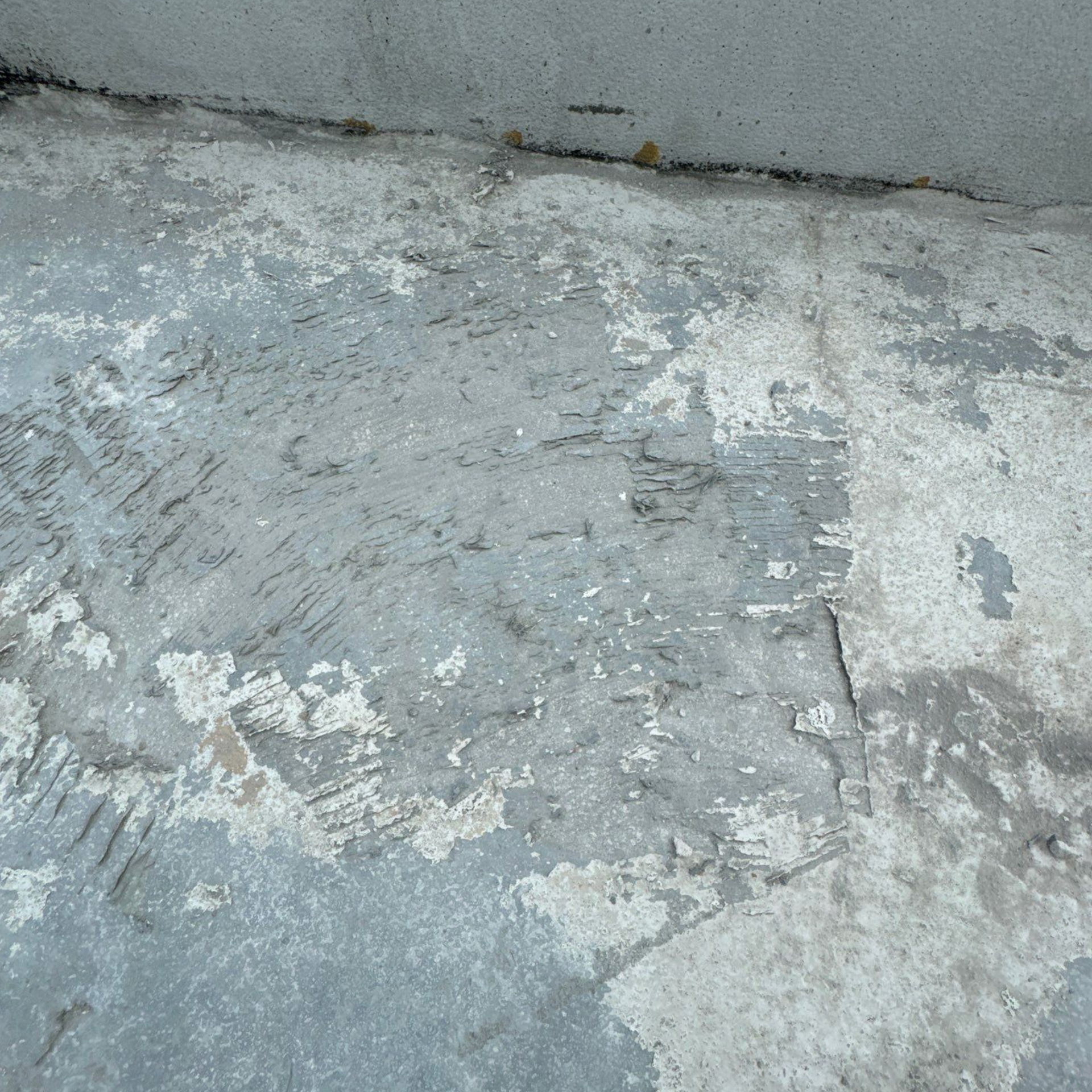 A close up of a gray concrete surface with white spots