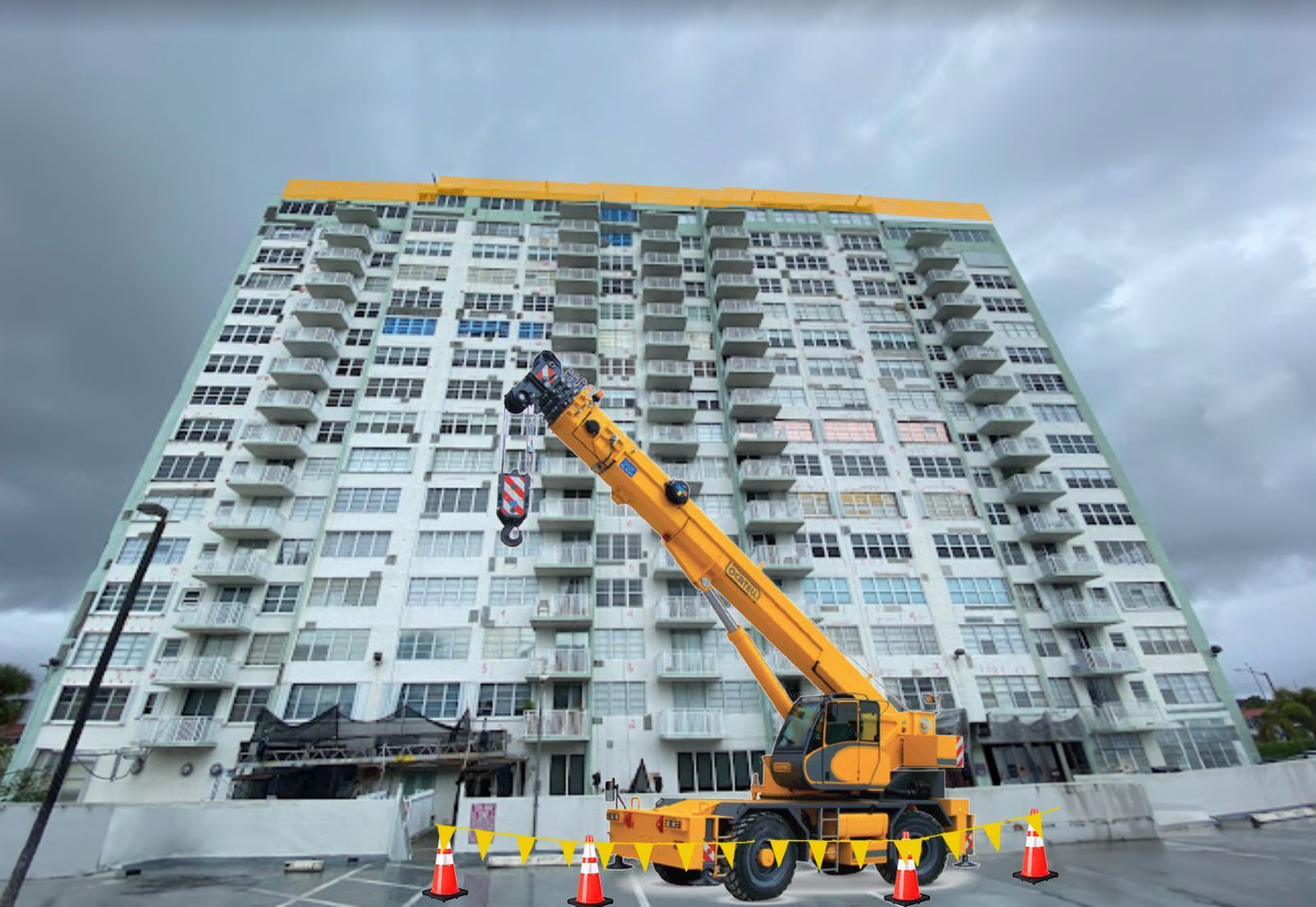 A yellow crane is sitting in front of a tall building.