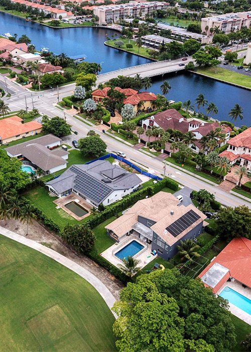 An aerial view of a residential area with a river in the background.