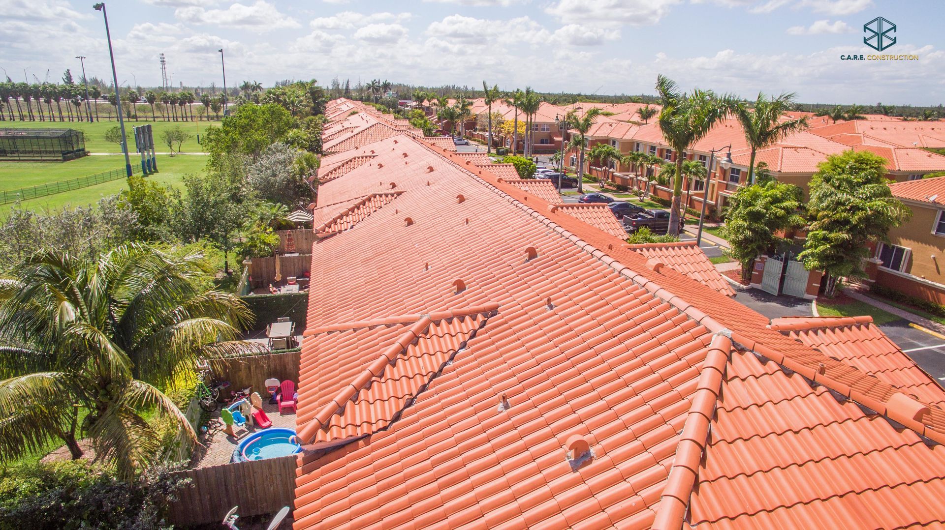 An aerial view of a row of houses with red tile roofs.