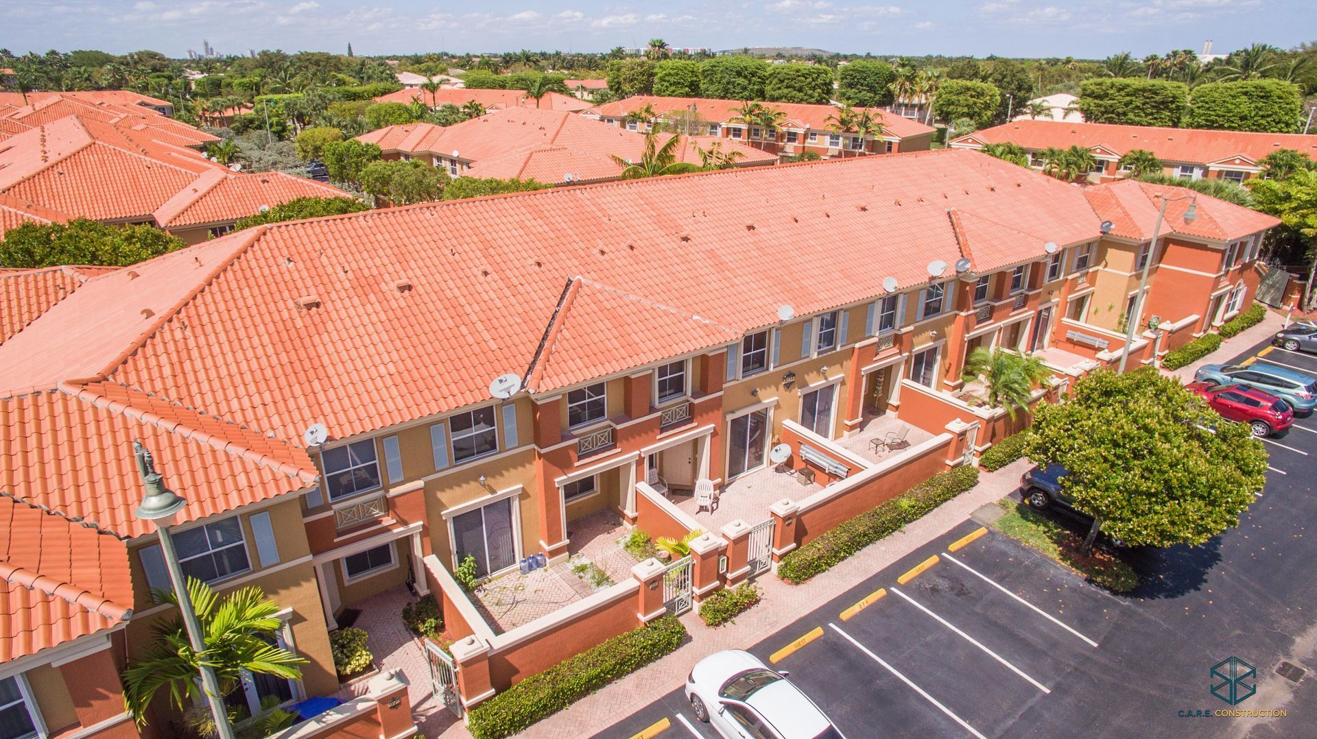 An aerial view of a row of houses with red tile roofs