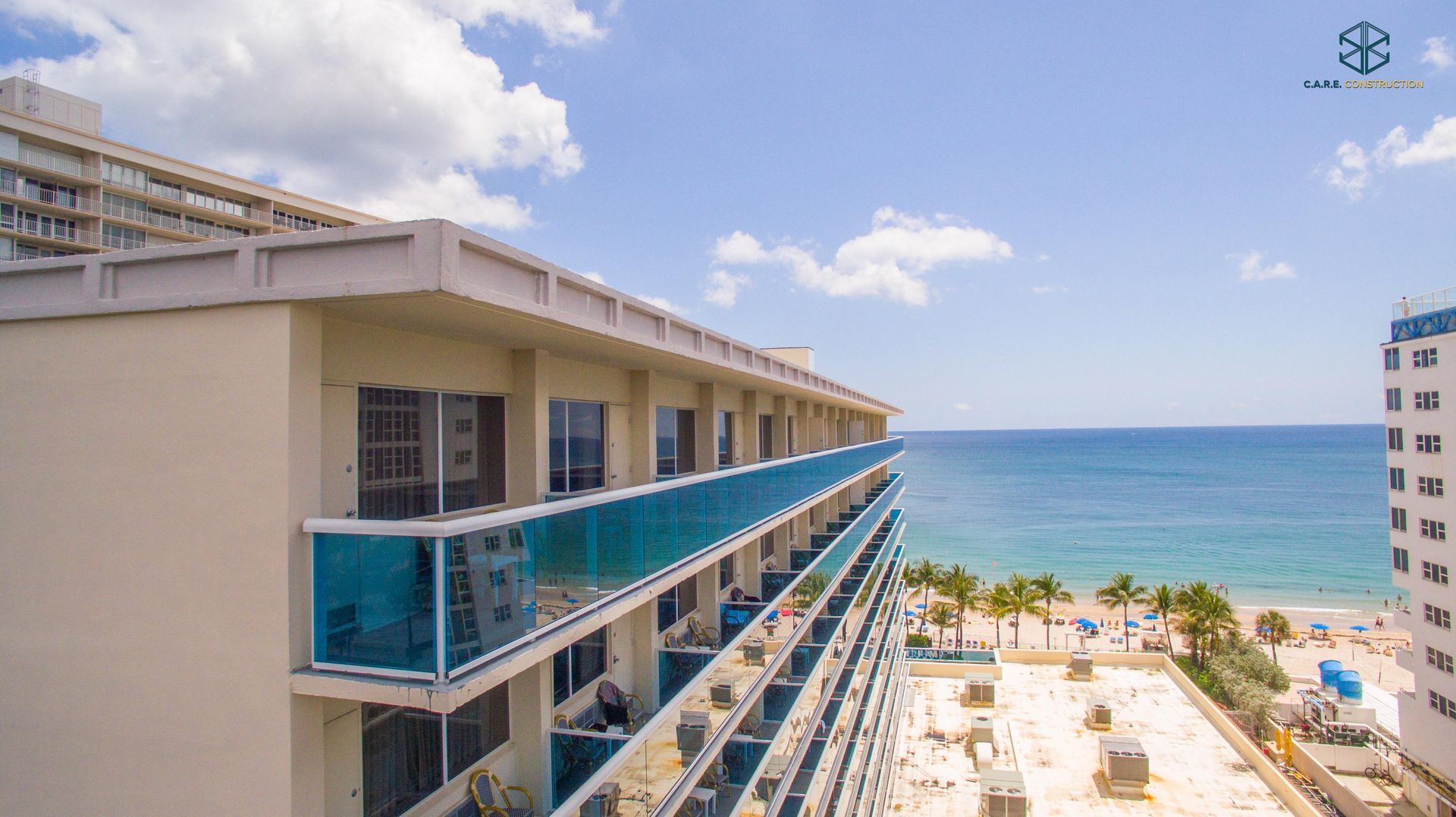 An aerial view of a hotel with balconies overlooking the ocean.