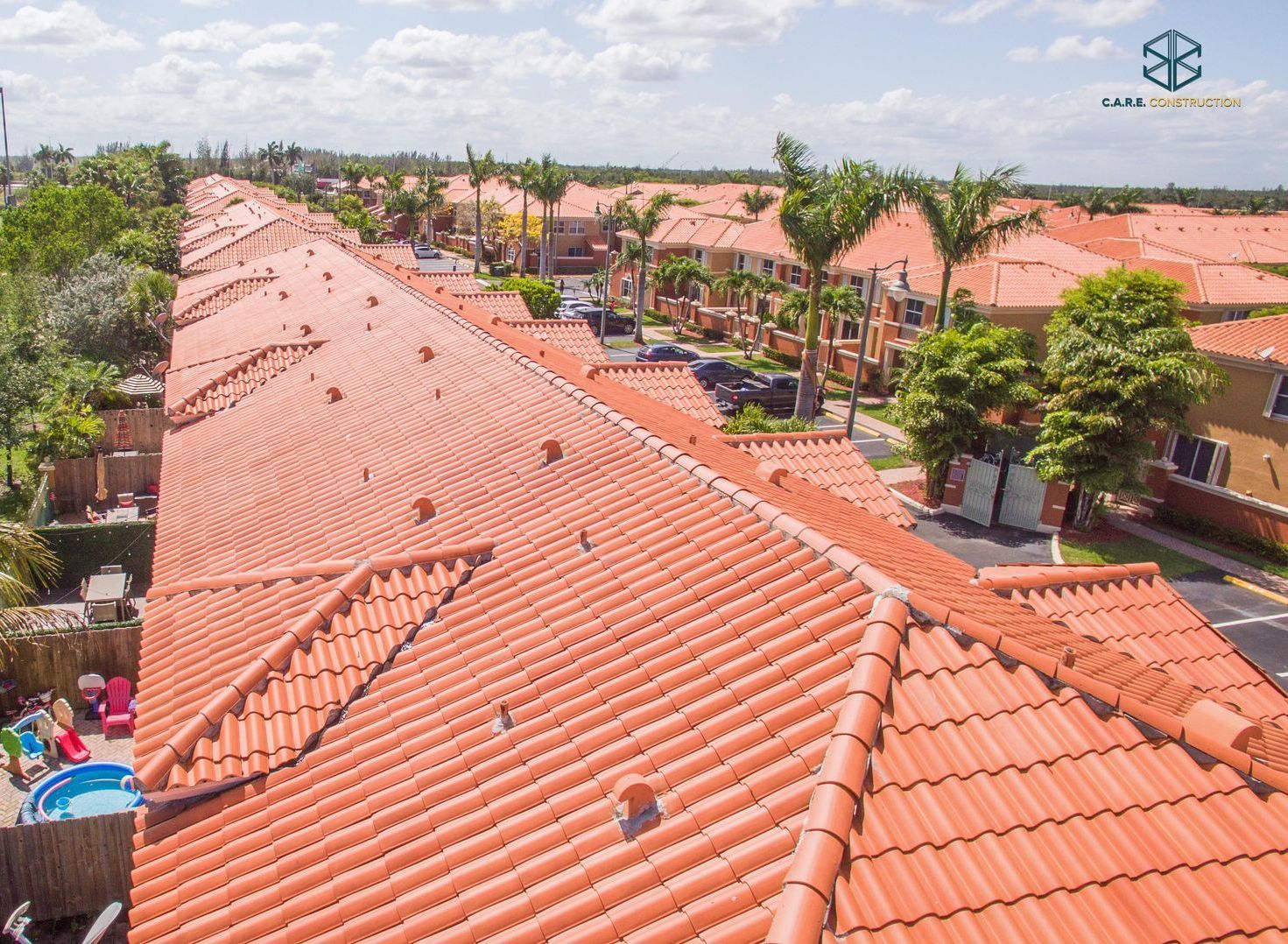 An aerial view of a row of houses with red tile roofs