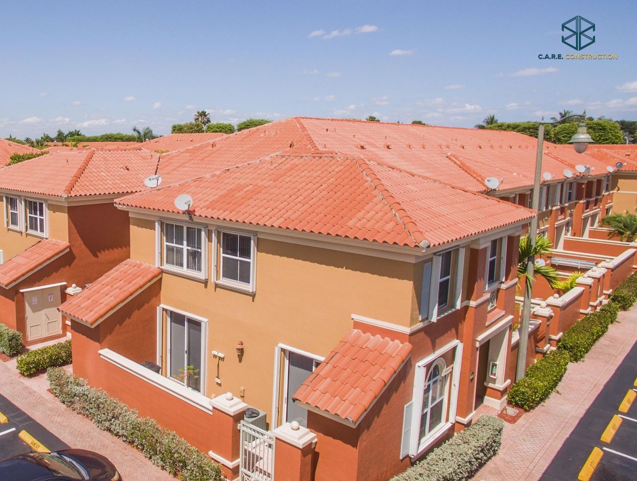 An aerial view of a row of houses with red tile roofs