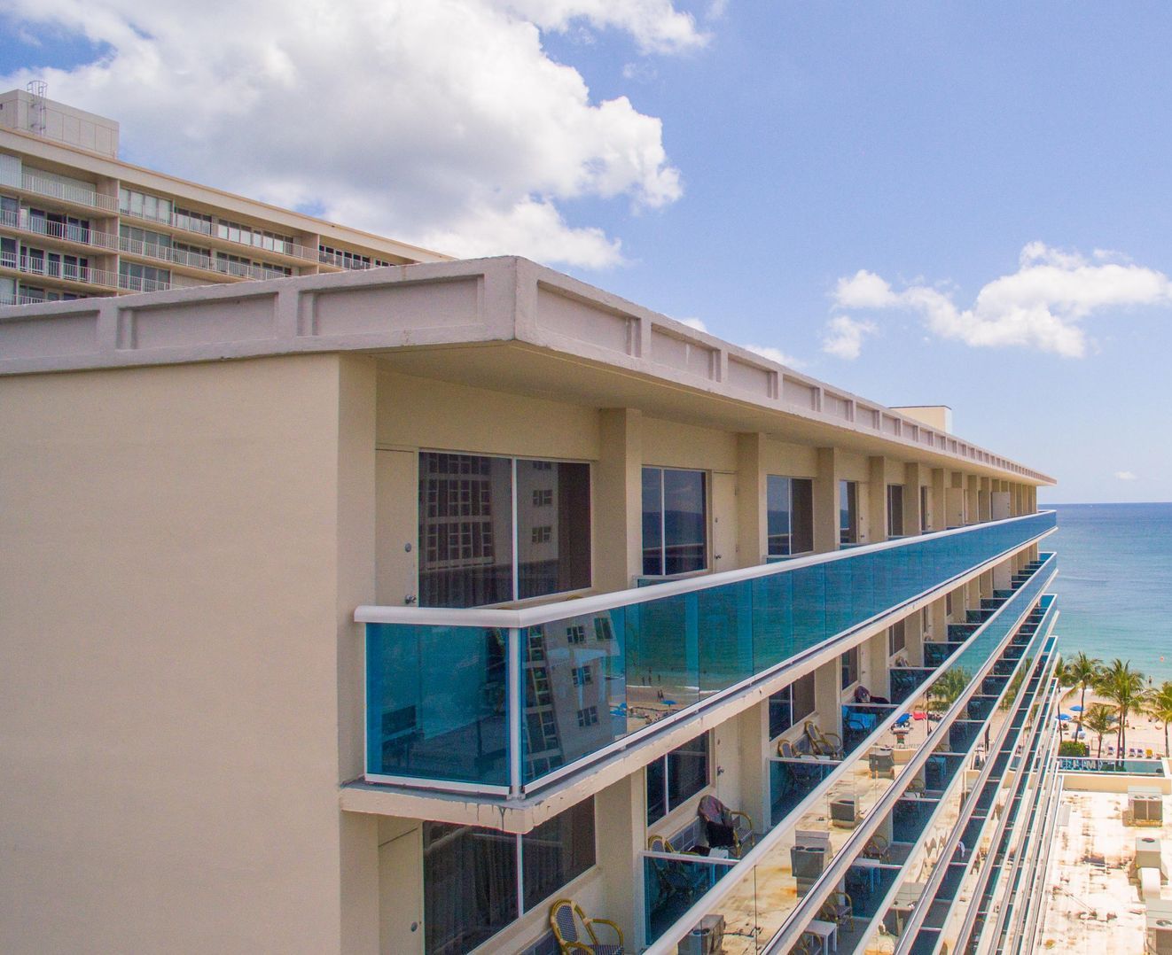An aerial view of a hotel with balconies overlooking the ocean.