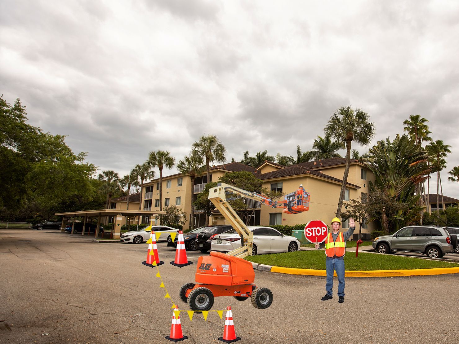 A man is holding a stop sign in a parking lot.