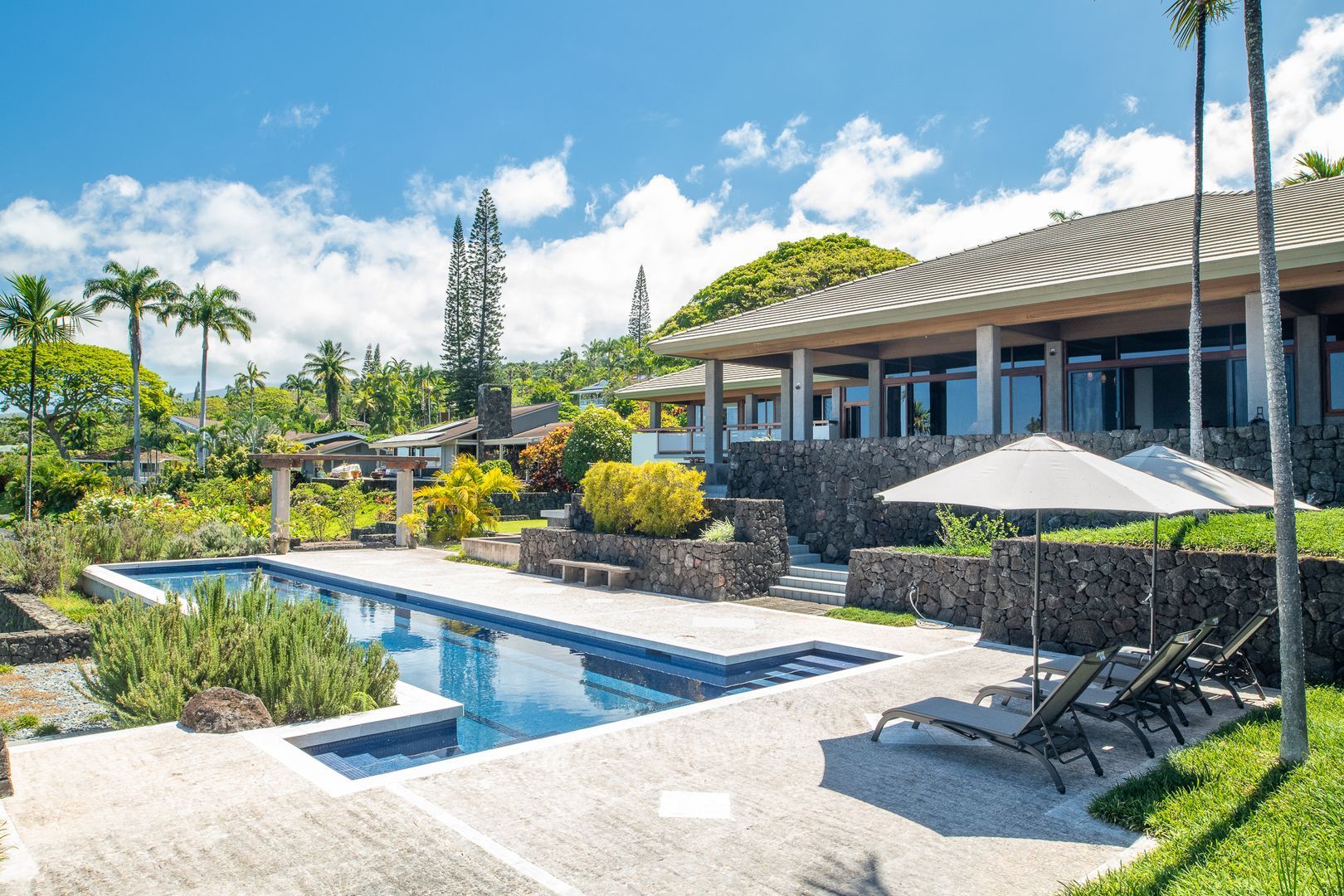 A scenic exterior shot of a Hawaiian rental property, showcasing its well-kept appearance and tropical landscaping.