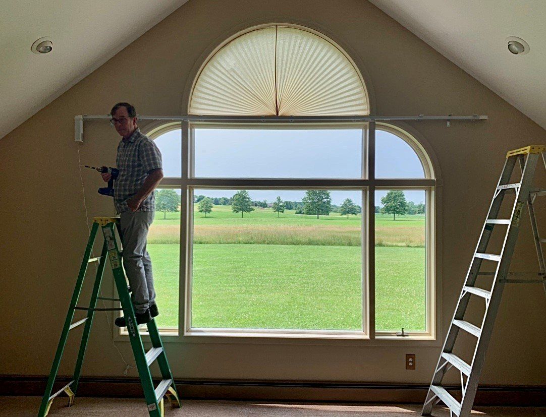 Man installing blinds — Erie, PA — Mcqueen Inc.