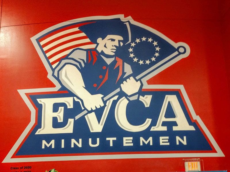 A logo for evca minutemen with a man holding an american flag