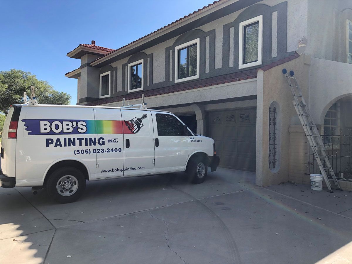 A bob 's painting van is parked in front of a house.