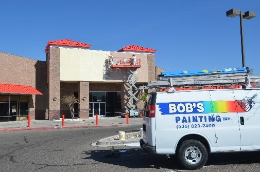 A bob 's painting van is parked in front of a building