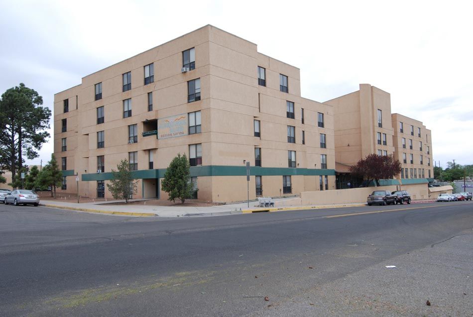 A large apartment building with cars parked in front of it