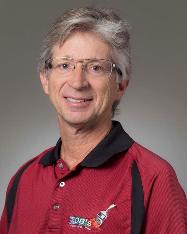 A man wearing glasses and a red shirt that says bob 's