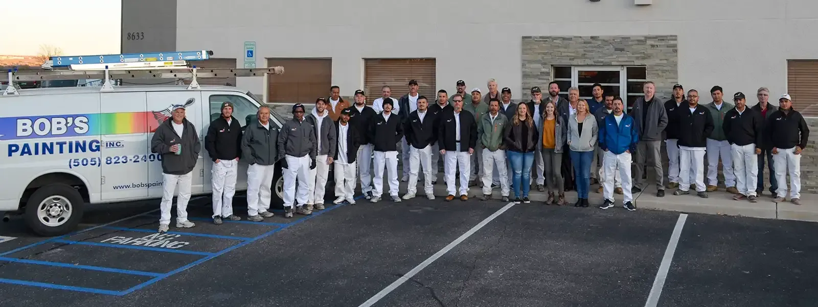 Bob 's painting team posing for a picture in front of their van