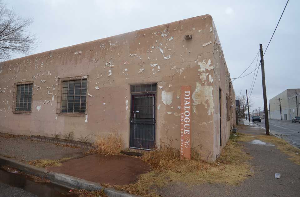 An old building with a sign on the side of it that says `` dialogue ''.