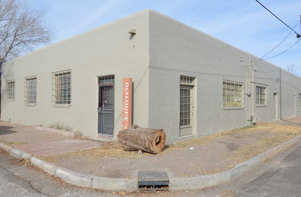 A large building is sitting on the corner of a street.