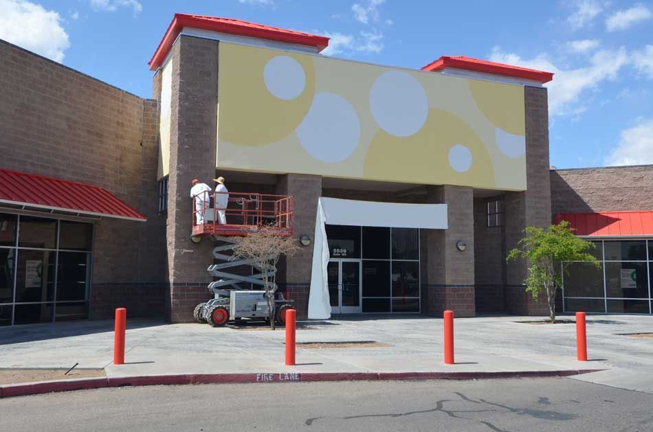 Two men are painting the side of a building