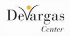 The devargas center logo is white with a yellow circle in the middle.