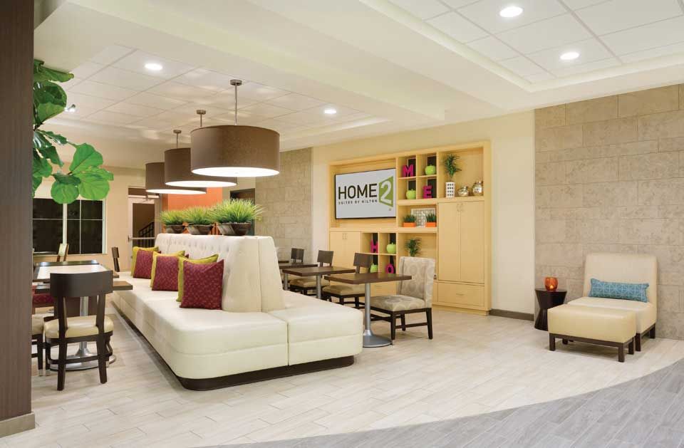 A hotel lobby with a couch and chairs and a sign that says homer